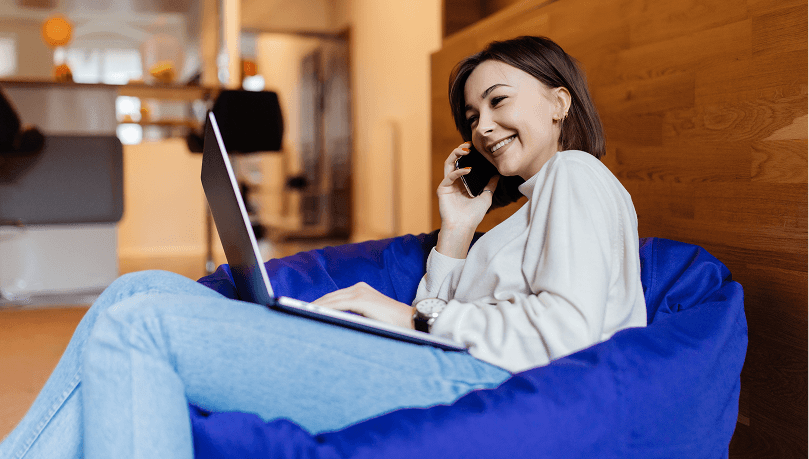 Resident on a laptop and phone in a lounge — reliable Wi‑Fi
